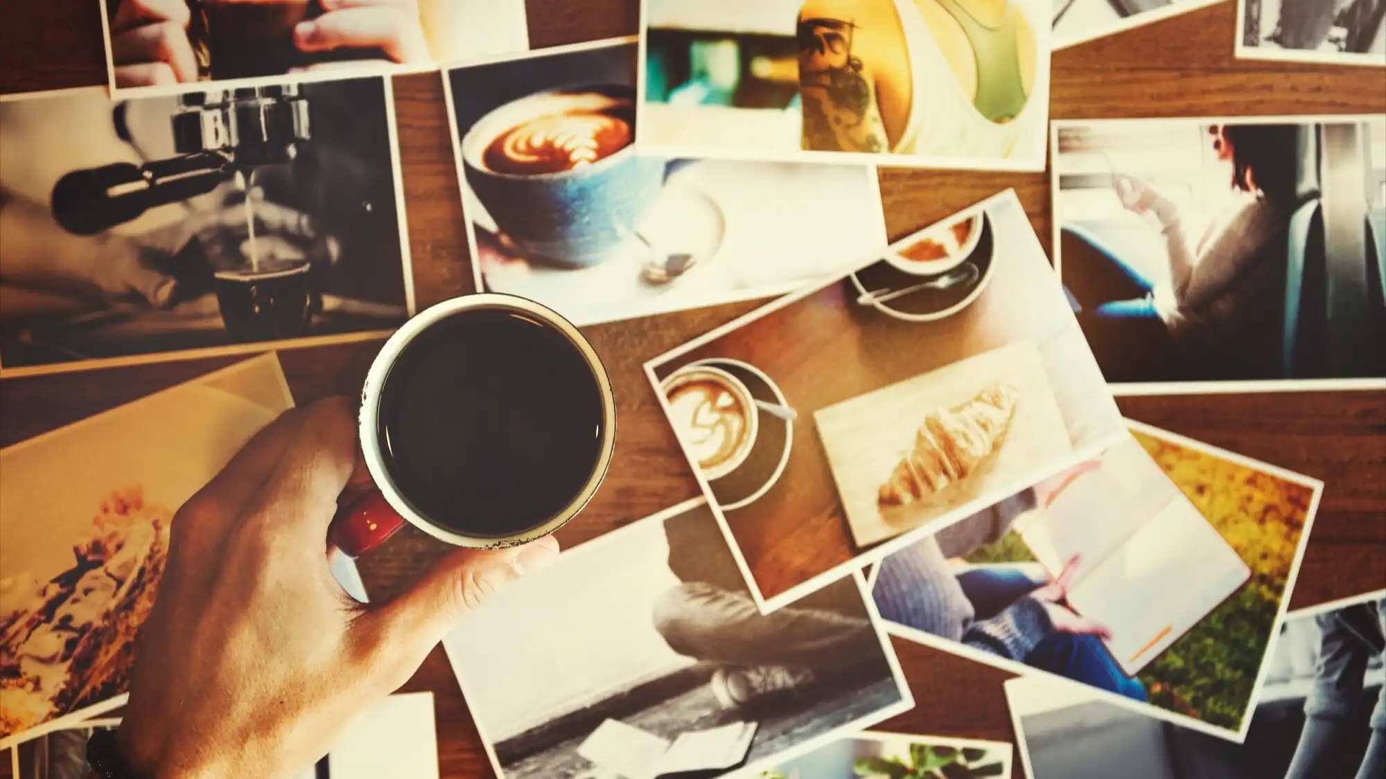 מאגר תמונות מפוזר על שולחן מעץ עם כוס קפה